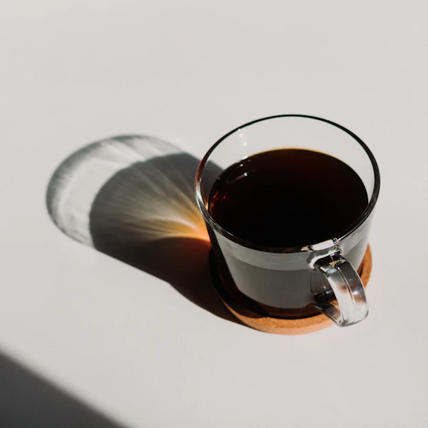 A glass of black coffee in morning light