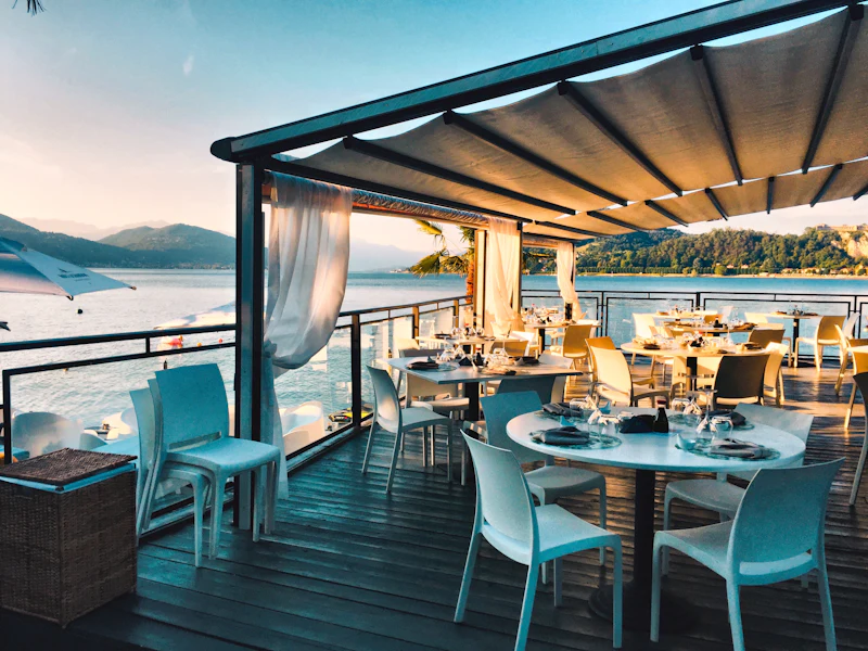 Tables on the waterfront terrace at golden hour